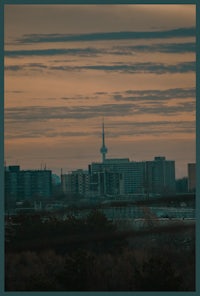 a city skyline with a tv tower in the background